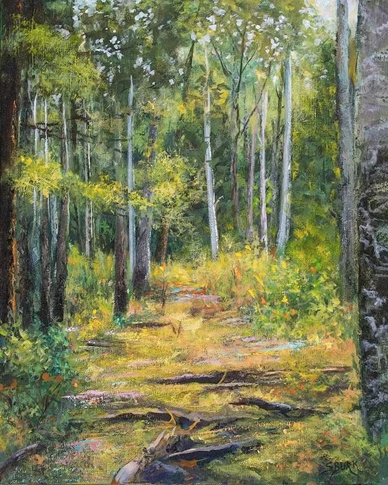 Beautiful woods glowing on the trails upward with lush colors of golds, yellows and greens surrounding the trees by Stephanie Burke.